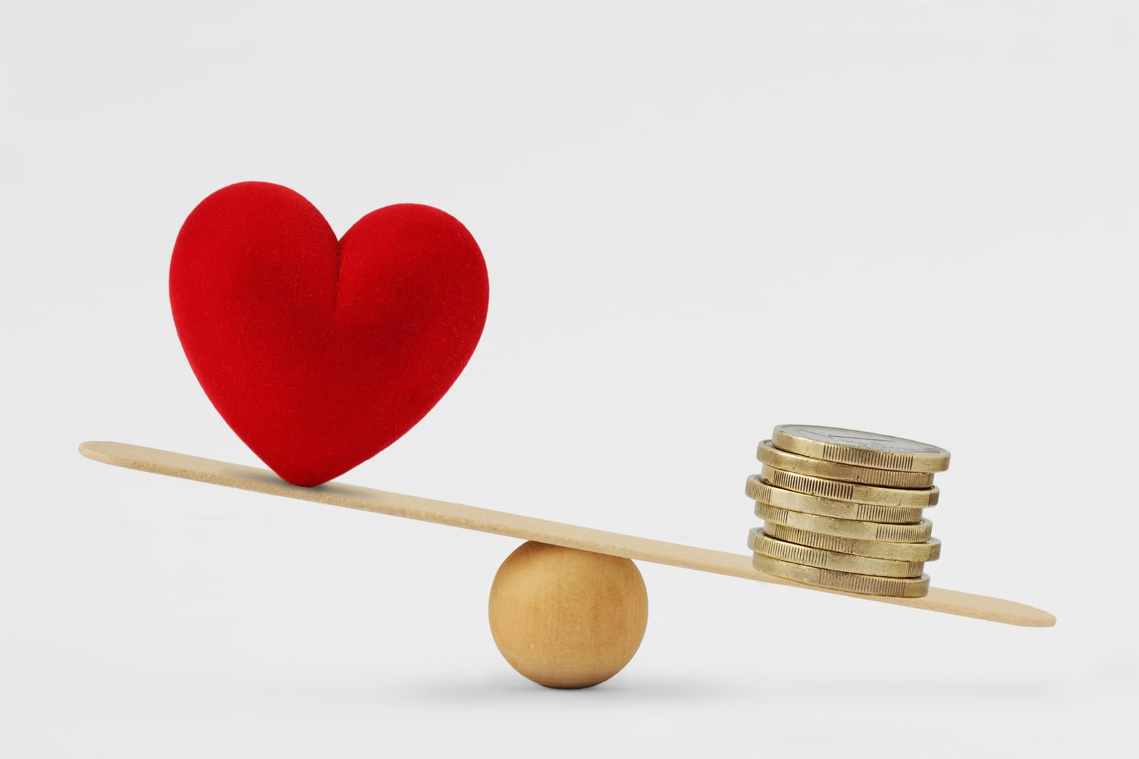 Heart and money on a balance scale